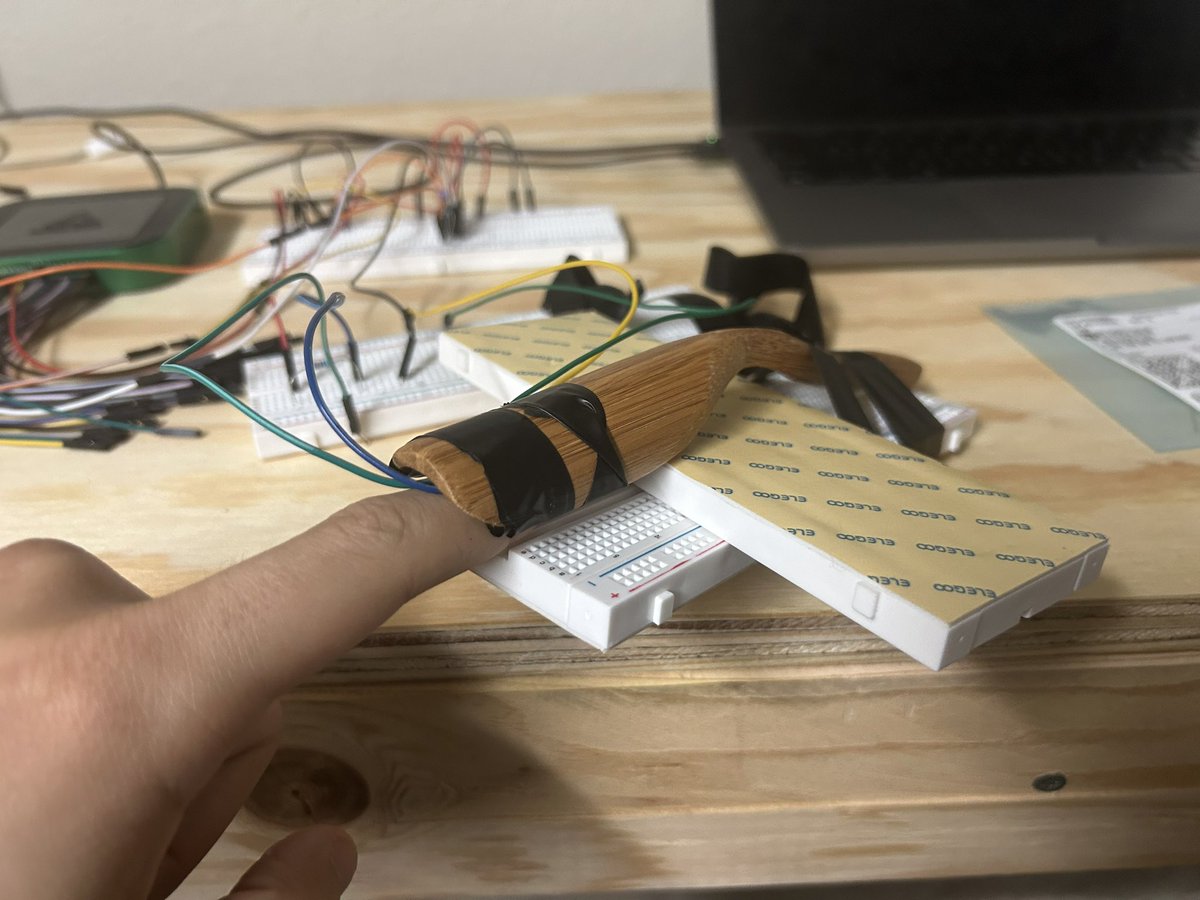 A fingertip in the handmade optical sensor connected to a breadboard